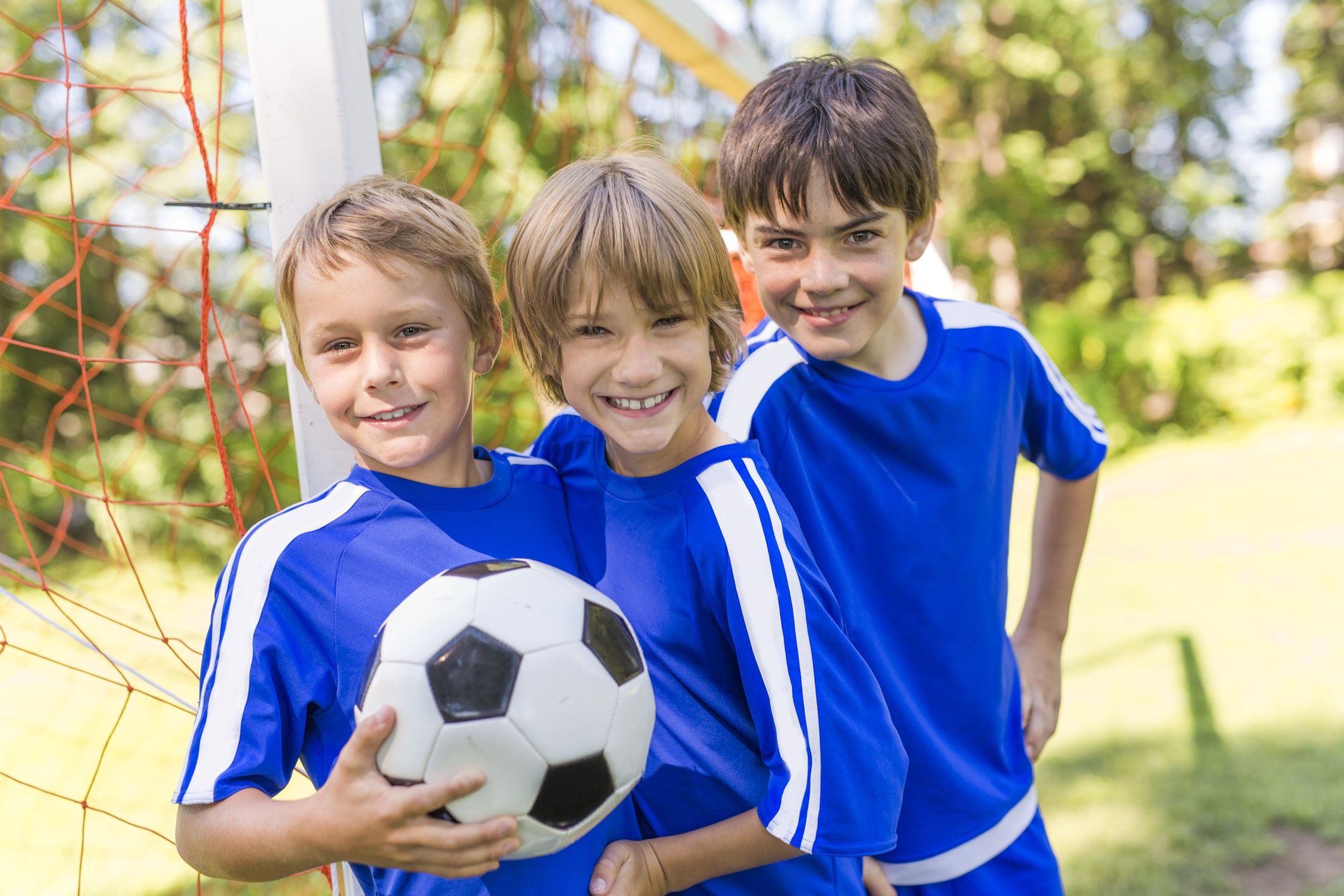three boys in soccer uniforms